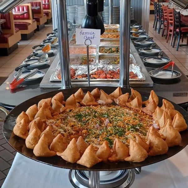 A large platter of samosa chaat with samosas arranged around the edge at Taj Mahal Grill & Bar.